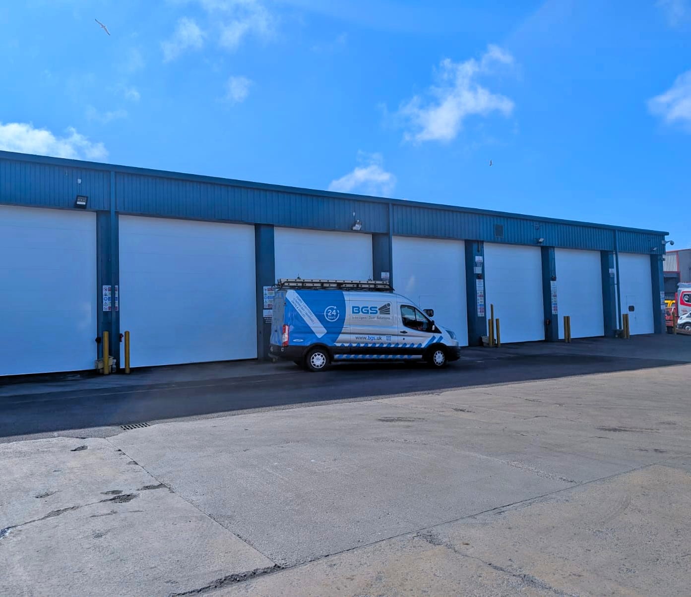 BGS van drives away after inspecting multiple sectional overhead door installations